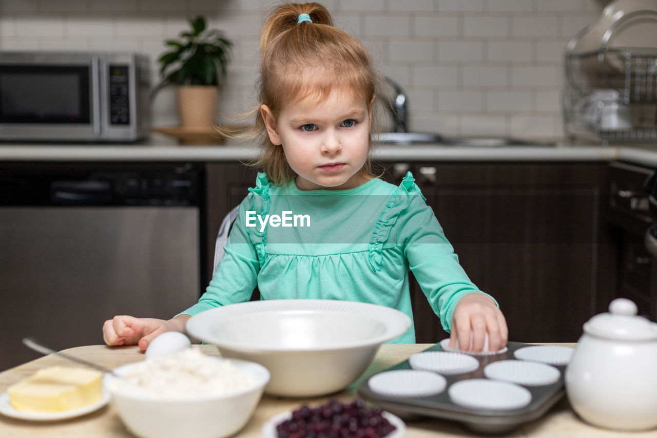 portrait of cute girl eating food in kitchen