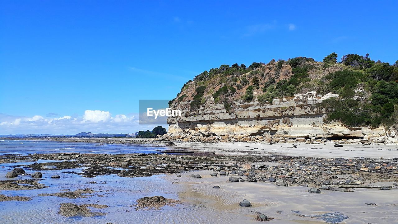 Scenic view of beach against blue sky