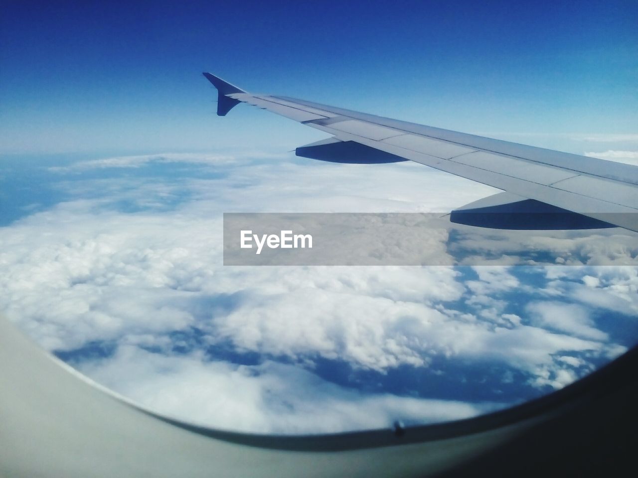 CROPPED IMAGE OF AIRPLANE WING OVER LANDSCAPE