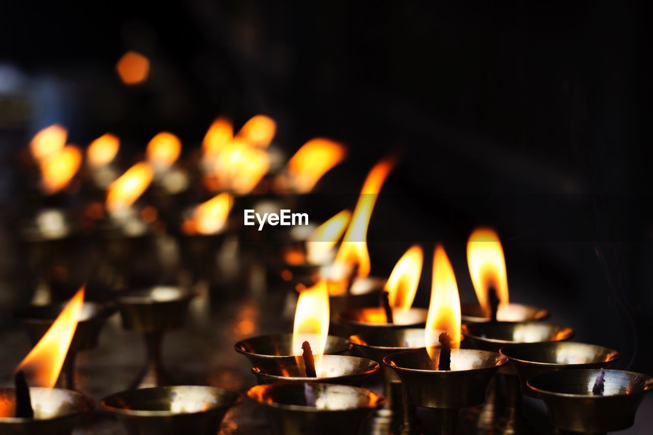 Close-up of burning diyas in temple