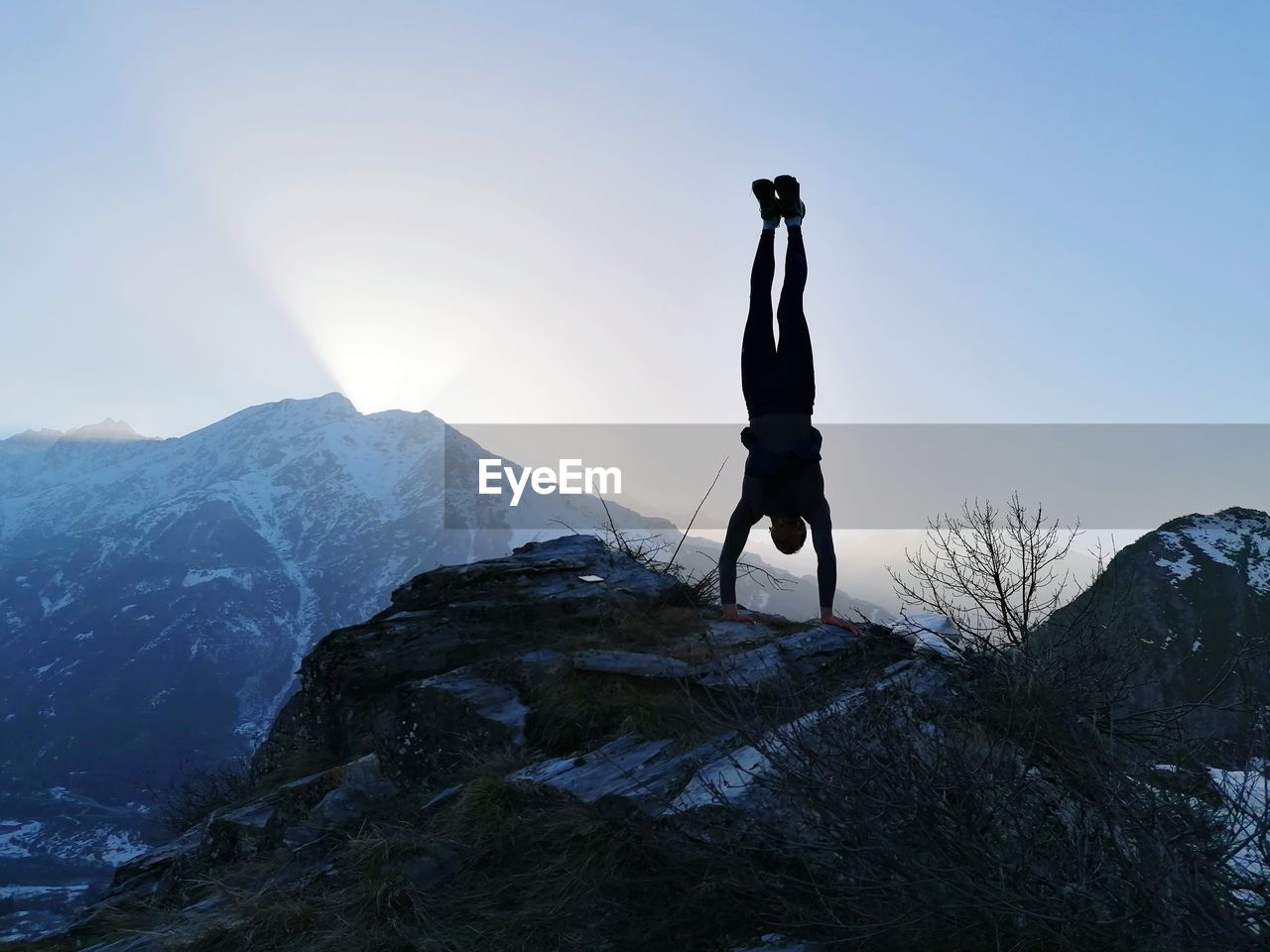 Man standing on snowcapped mountain against sky