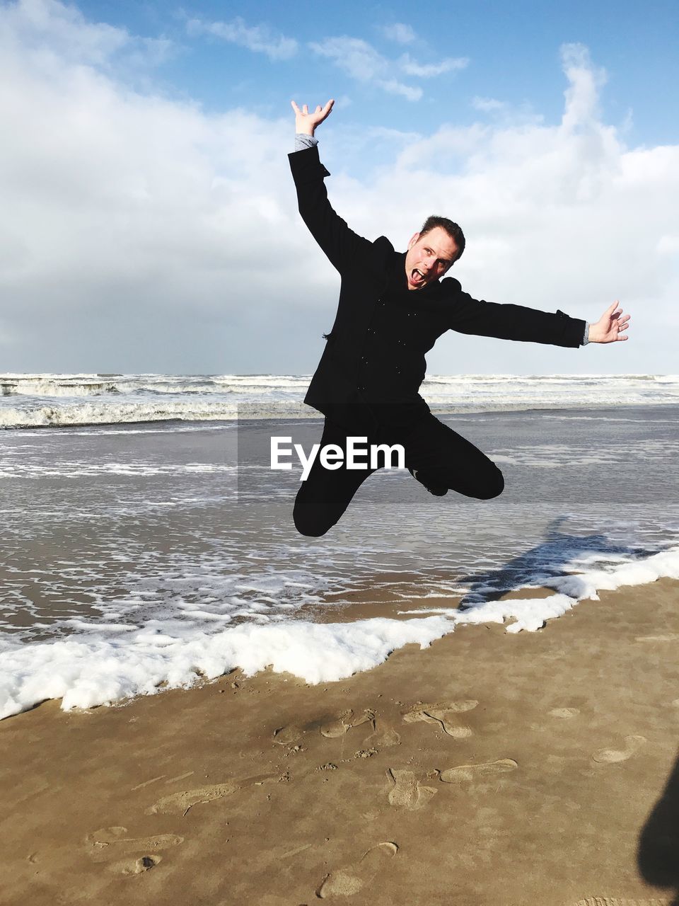 Man jumping on shore at beach