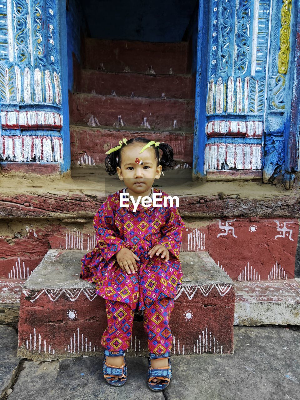 Portrait of girl sitting at entrance