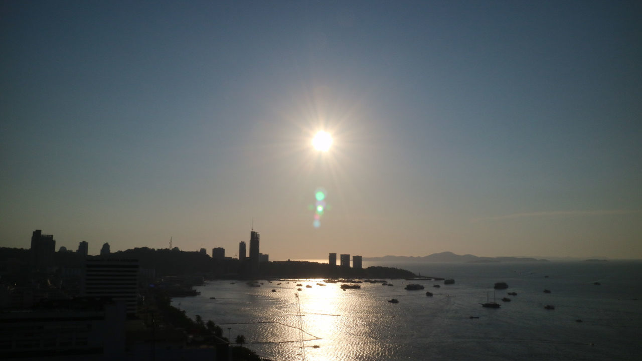 Scenic view of sea by city against sky