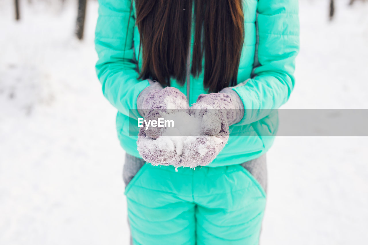 MIDSECTION OF WOMAN HOLDING ICE
