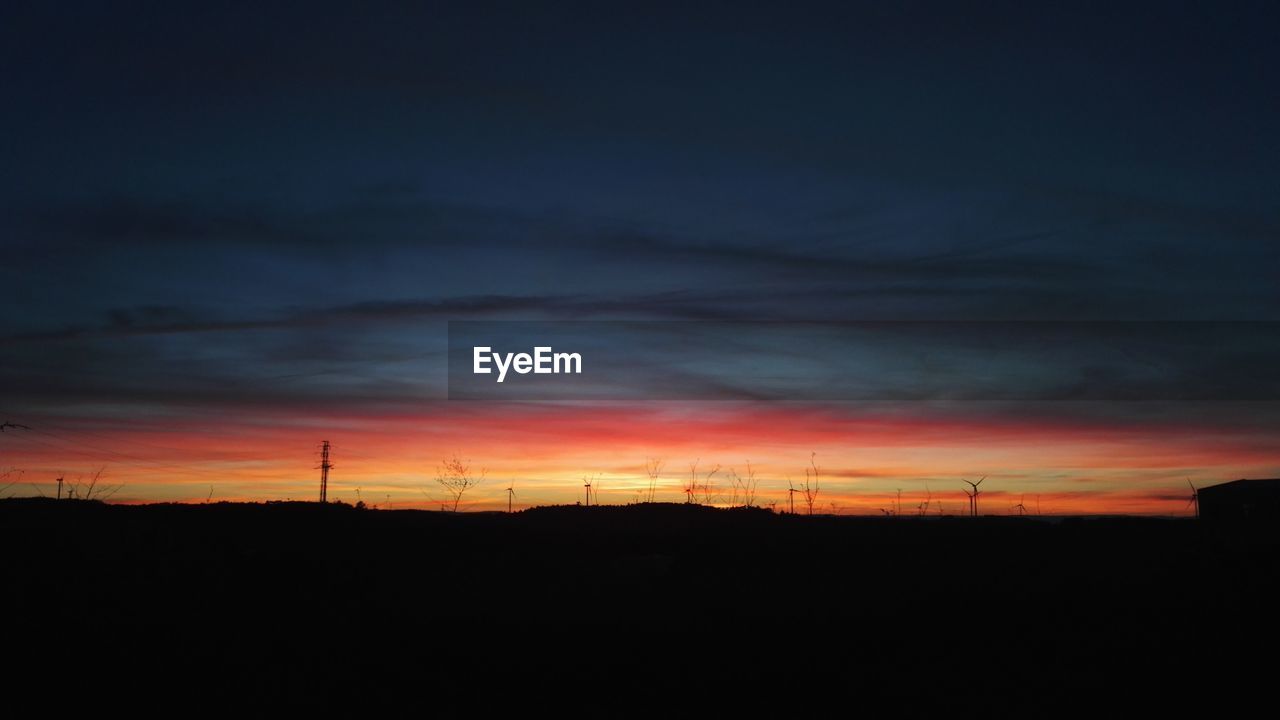 SILHOUETTE OF ELECTRICITY PYLONS AT SUNSET