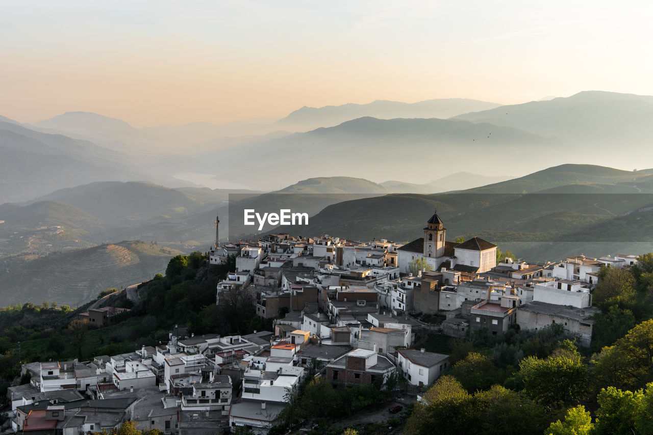 High angle view of townscape and mountains against sky