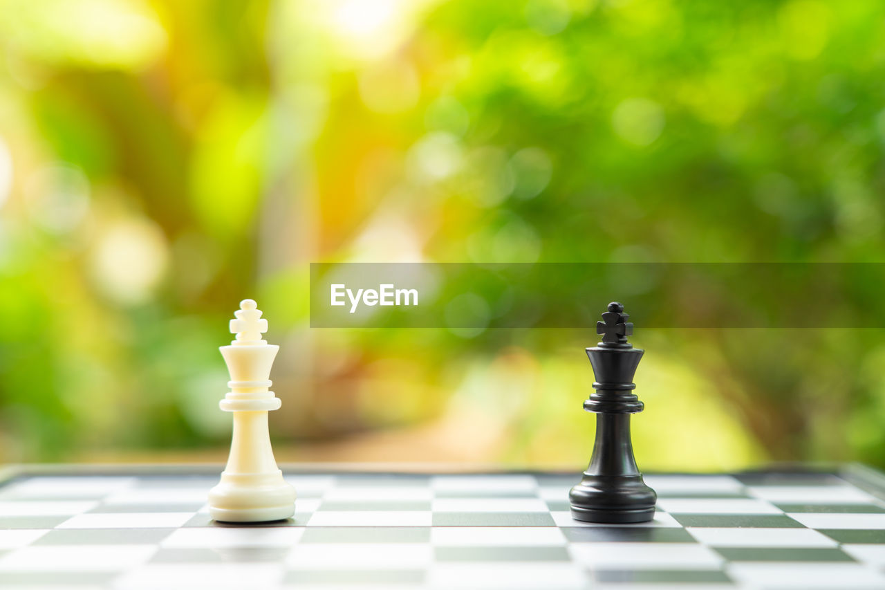 CLOSE-UP OF CHESS PIECES ON FLOOR AGAINST BLURRED BACKGROUND