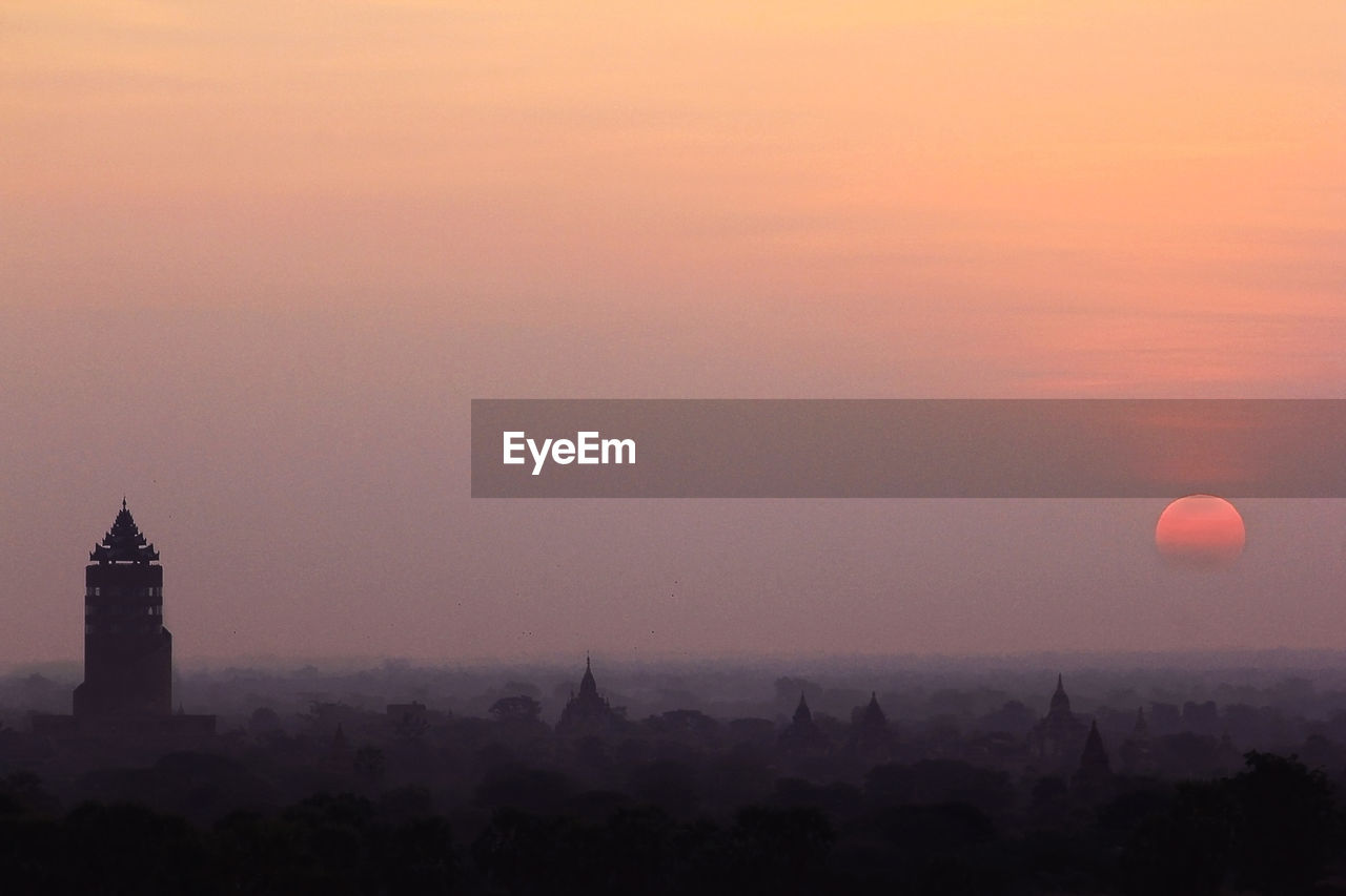 Silhouette buildings against sky during sunset