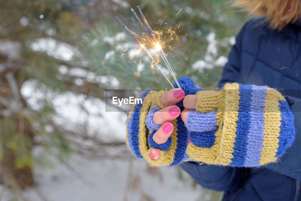 Midsection of woman holding sparkler