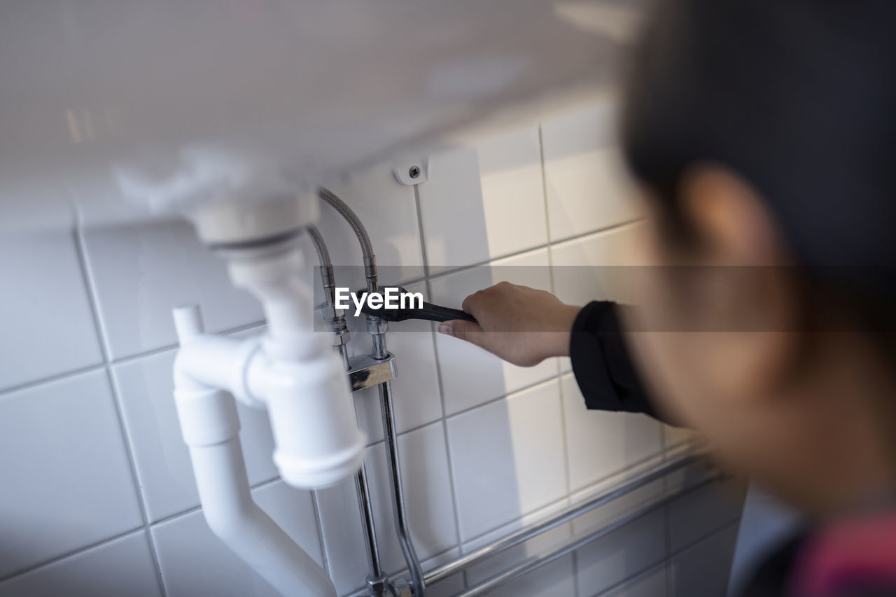 Woman fixing bathroom sink