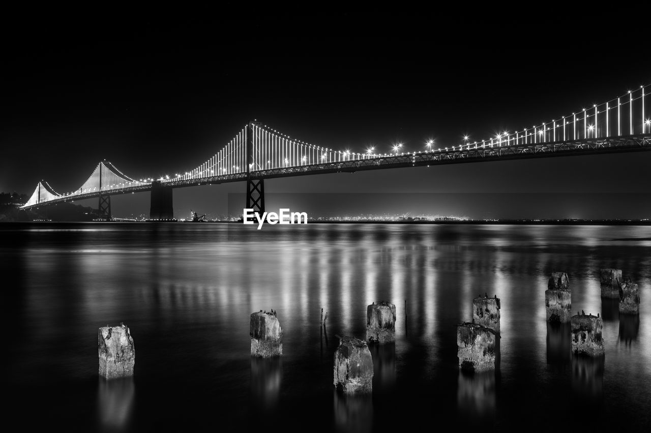 View of suspension bridge over river at night