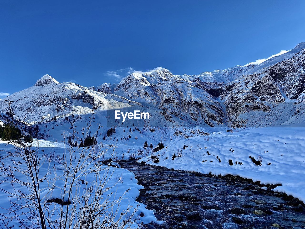 Scenic view of snowcapped mountains against clear blue sky