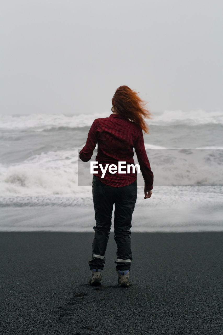 Woman on windy reynisfjara black beach scenic photography