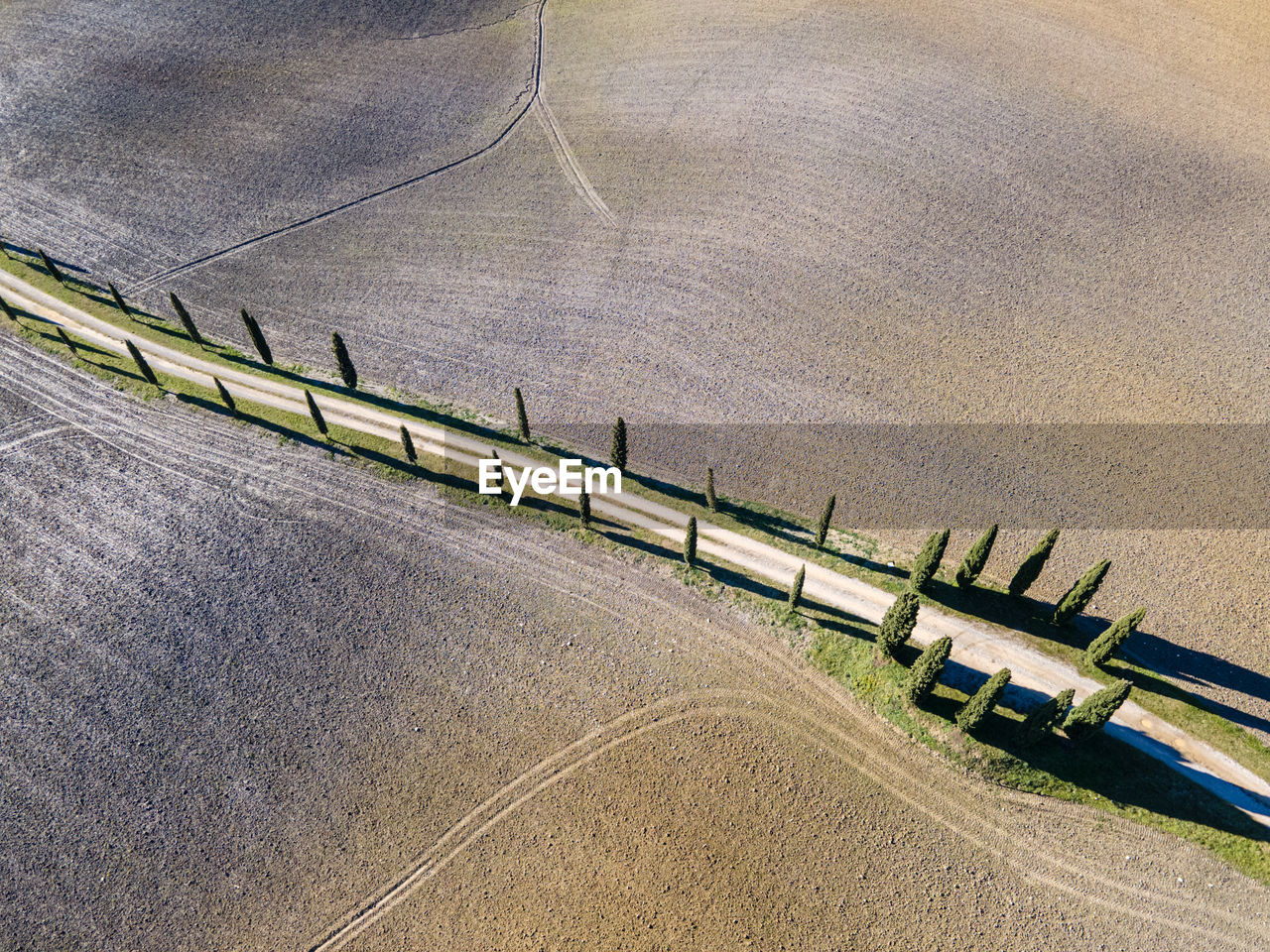 HIGH ANGLE VIEW OF VEHICLES ON ROAD BY FIELD