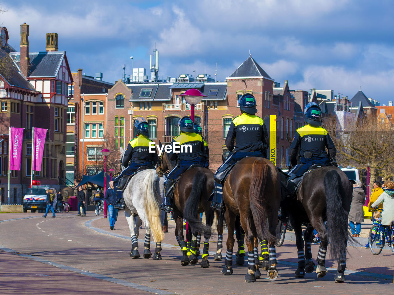 HORSES IN CITY AGAINST CLOUDY SKY