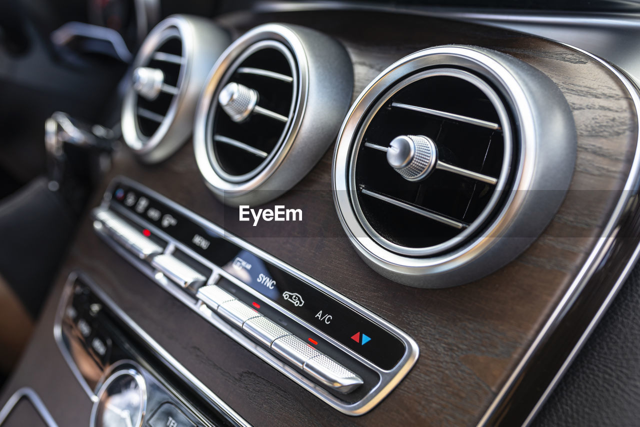 The interior of a modern passenger car with three vents visible and air conditioning control.