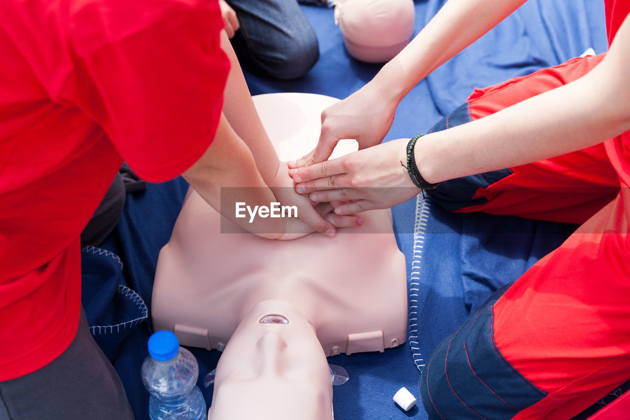 Volunteers giving first aid training with mannequin