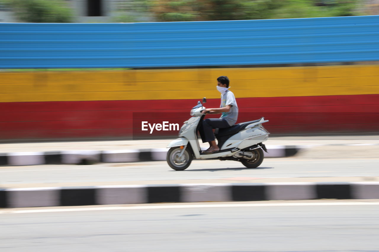 MAN RIDING MOTORCYCLE ON CART