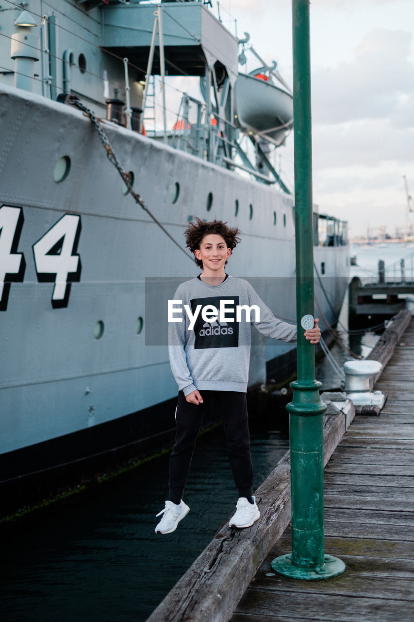 PORTRAIT OF YOUNG MAN STANDING IN WATER