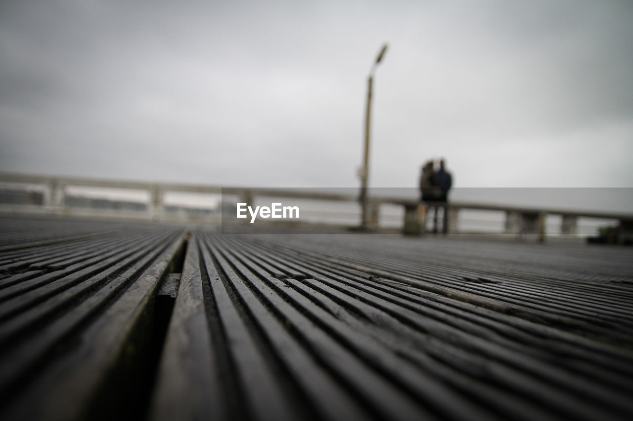 Surface level of footbridge against sky