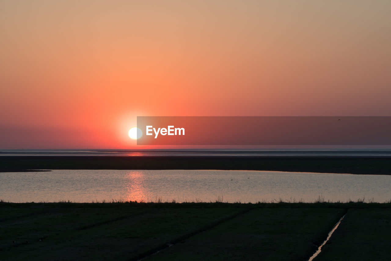 SCENIC VIEW OF SEA AGAINST SKY AT SUNSET