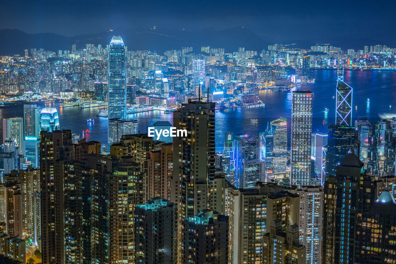 AERIAL VIEW OF ILLUMINATED CITY BUILDINGS AT NIGHT