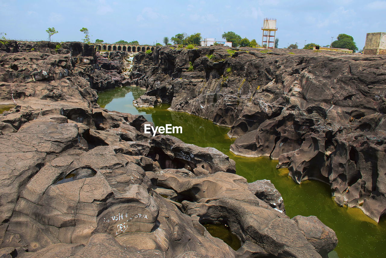 ROCK FORMATIONS ON SHORE AGAINST SKY