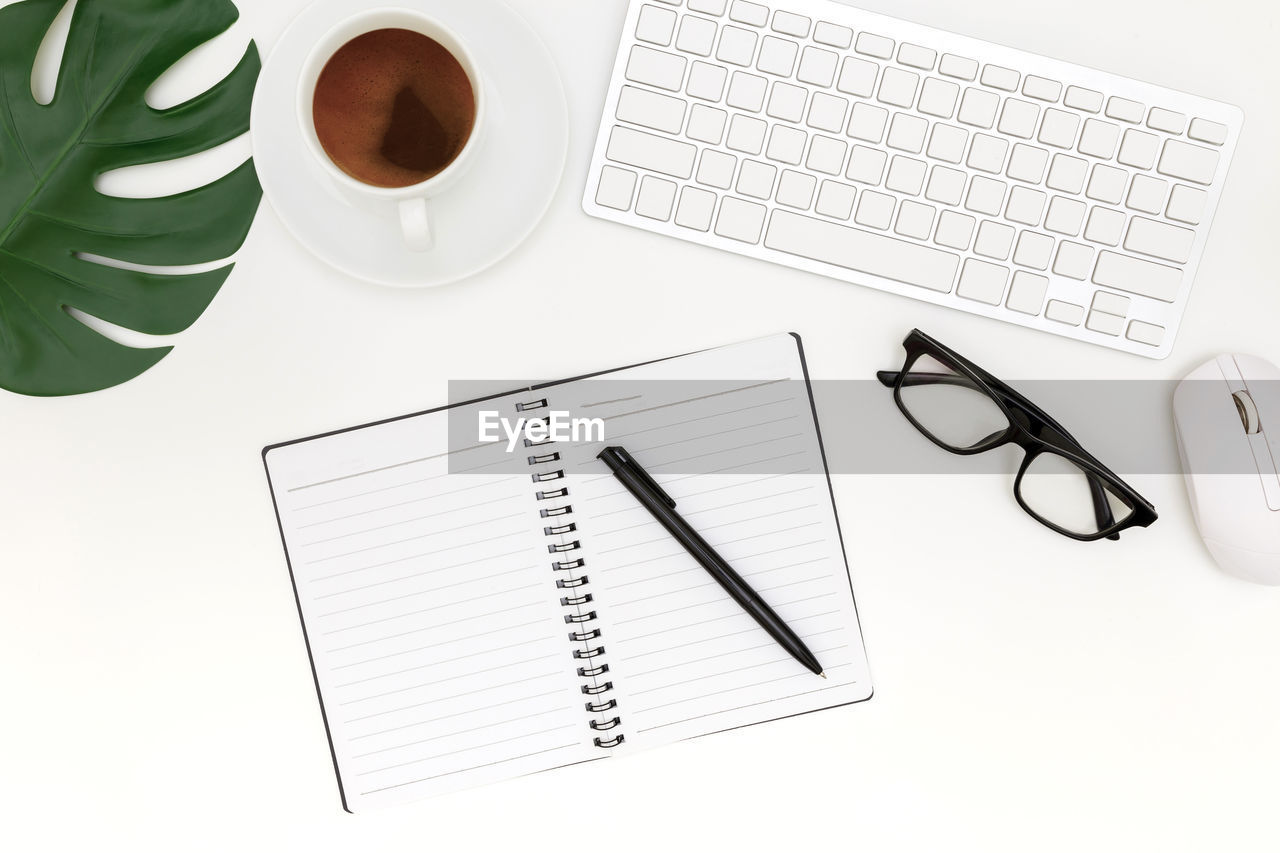 HIGH ANGLE VIEW OF COFFEE CUP WITH TEXT ON PAPER