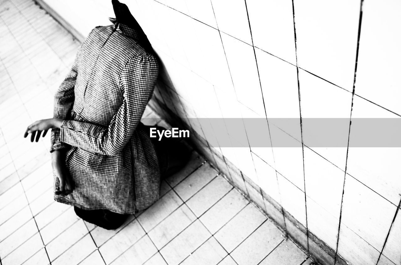 Rear view of woman looking through wall in building