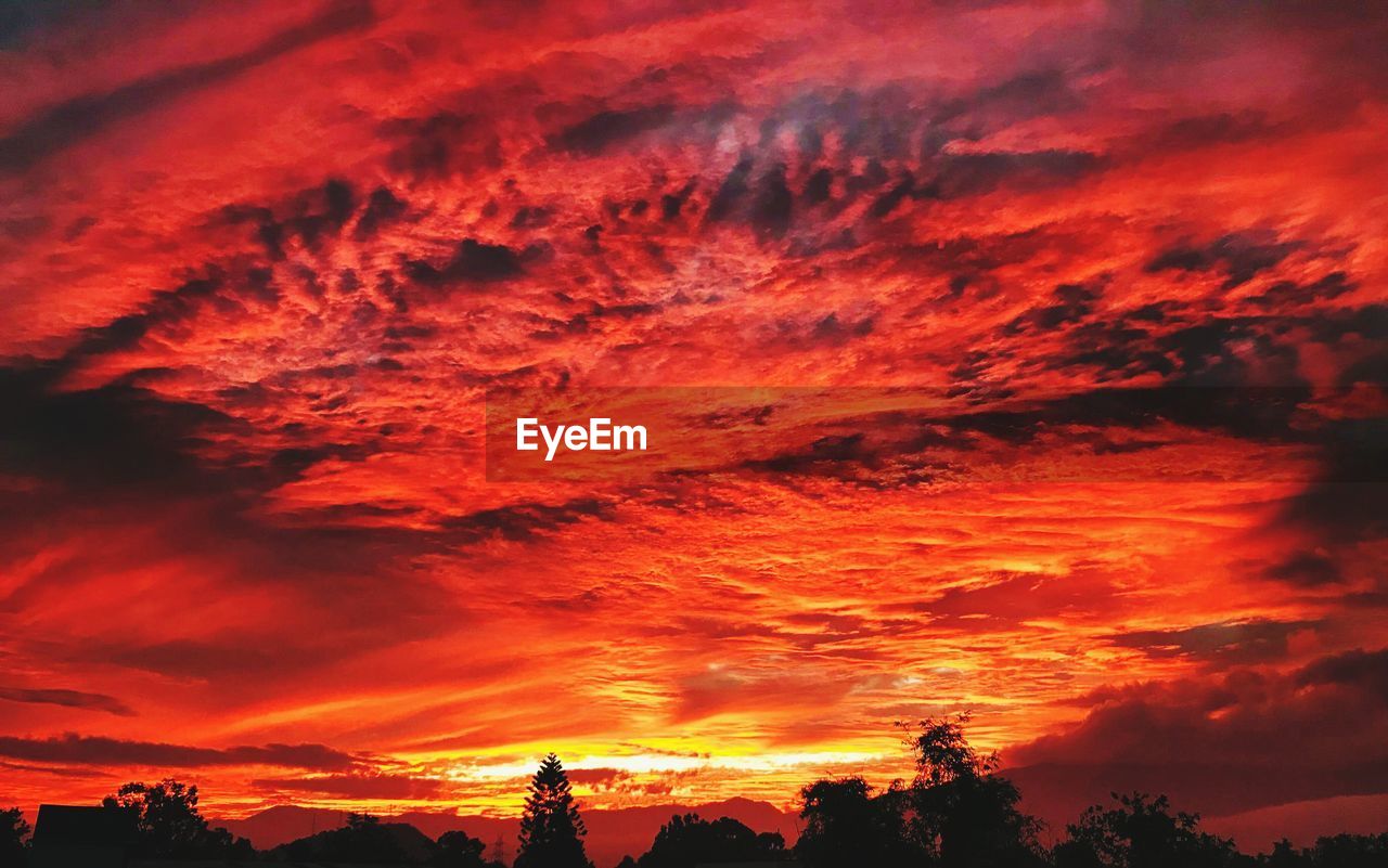 sky, afterglow, red sky at morning, cloud, sunset, beauty in nature, dramatic sky, scenics - nature, orange color, nature, silhouette, environment, red, tranquility, landscape, dawn, tree, tranquil scene, no people, idyllic, mountain, outdoors, cloudscape, plant, evening, atmospheric mood, multi colored, land, travel destinations, awe, romantic sky, horizon, moody sky, non-urban scene, sun