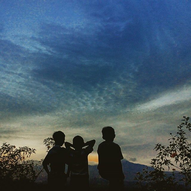 SILHOUETTE OF GIRL PLAYING AGAINST CLOUDY SKY