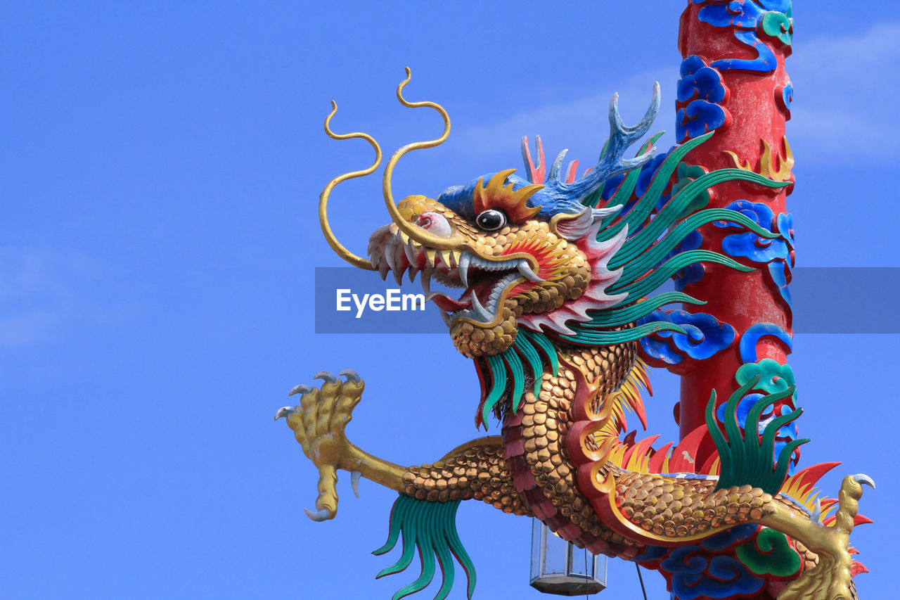 dragon, sky, chinese dragon, animal representation, tradition, animal, blue, nature, animal themes, representation, sculpture, craft, multi colored, no people, chinese new year, event, religion, outdoors, history, mythical creature, statue, architecture, celebration, belief, clear sky, the past