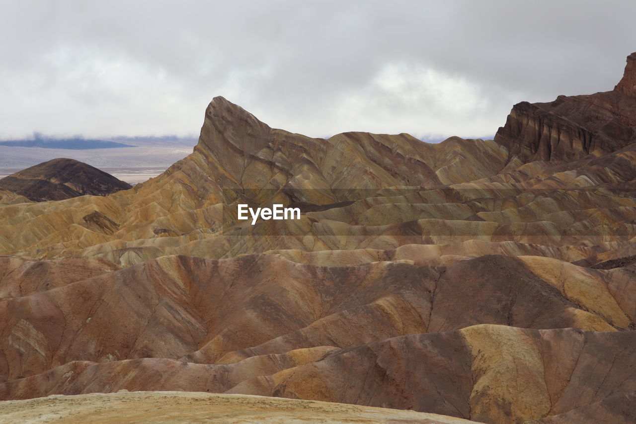 landscape, rock, environment, scenics - nature, cloud, land, sky, rock formation, nature, desert, beauty in nature, geology, mountain, non-urban scene, travel destinations, wadi, natural environment, no people, terrain, climate, travel, plateau, extreme terrain, arid climate, valley, physical geography, outdoors, tranquility, formation, day, tranquil scene, remote, mountain range, fossil, tourism, barren, wilderness, eroded