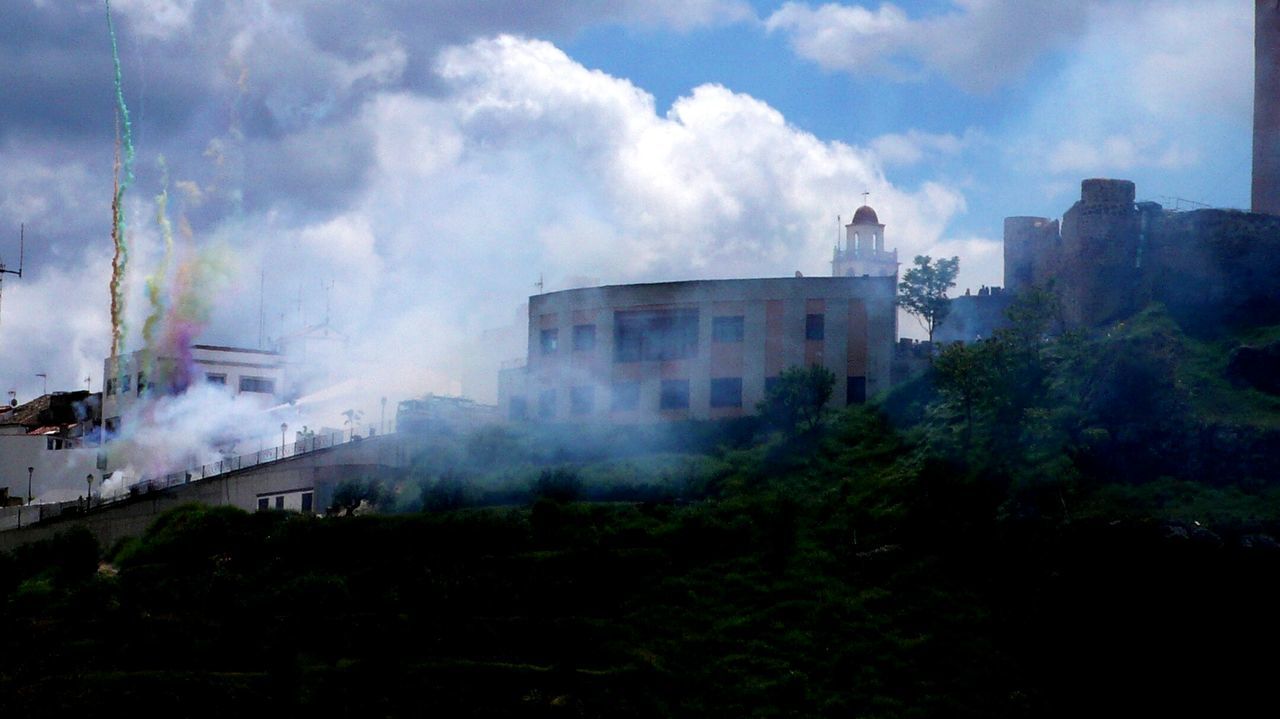 High section of built structures against clouds