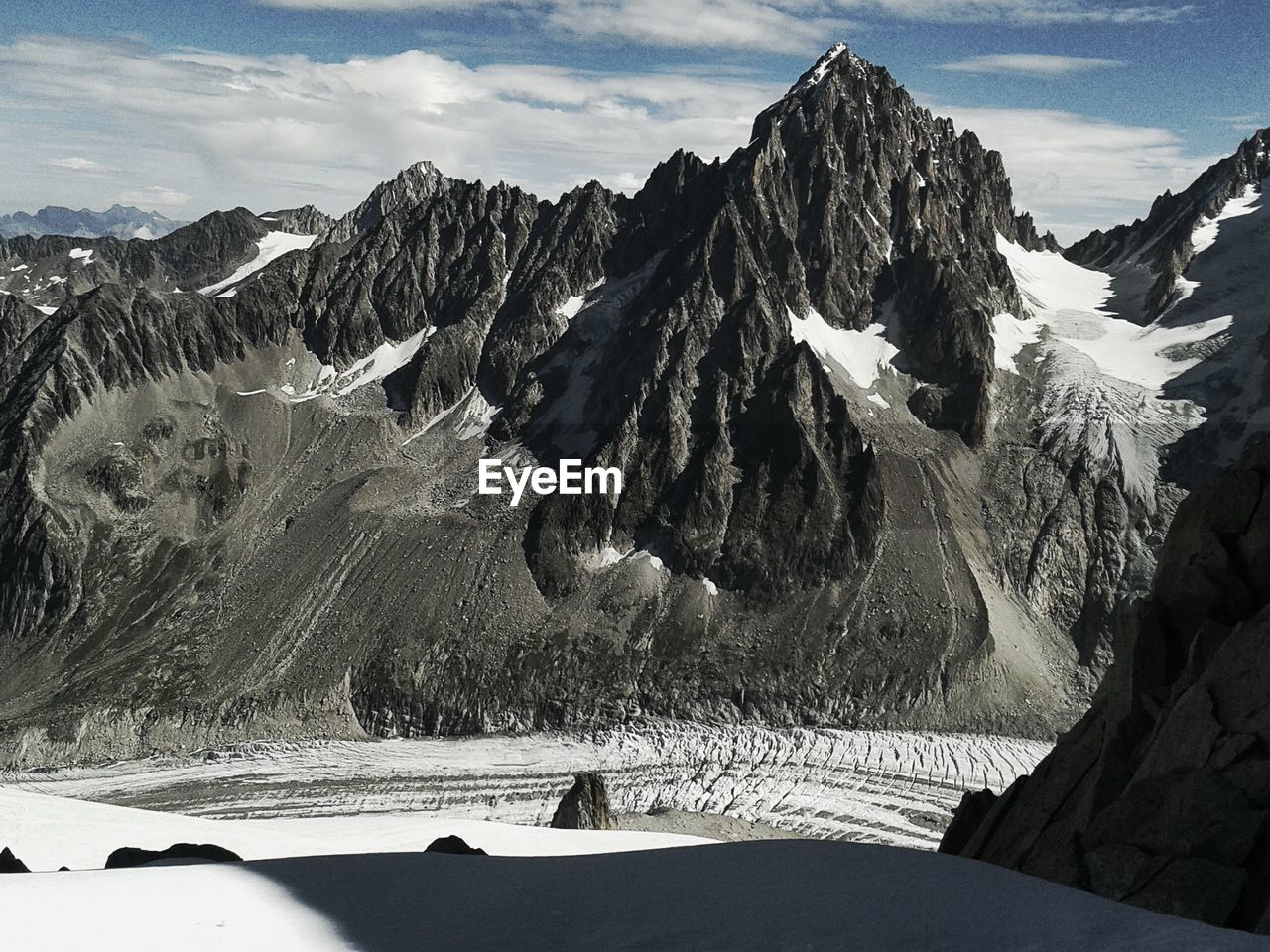 Scenic view of mountain range against cloudy sky