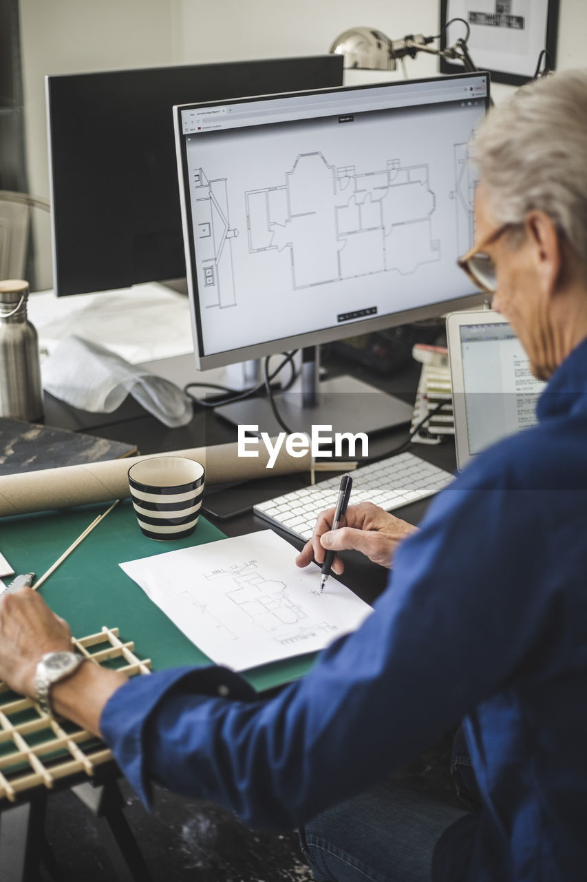 Craftsman examining while working on computer at office