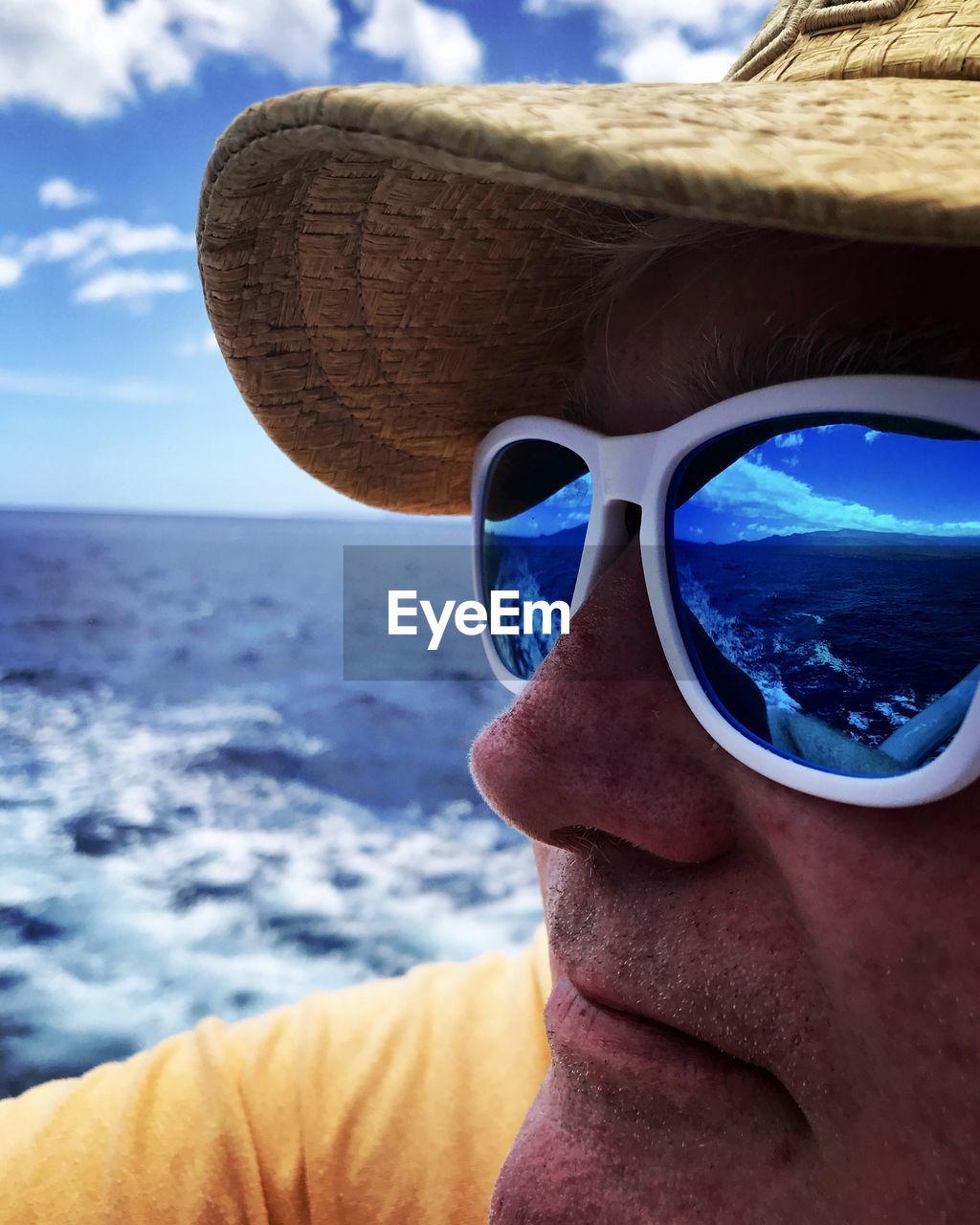 Close-up of man wearing sunglasses by sea