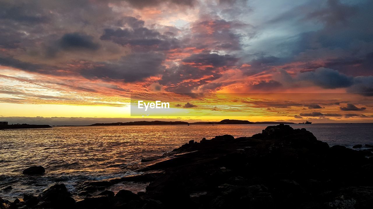 SCENIC VIEW OF SEA AGAINST ORANGE SKY