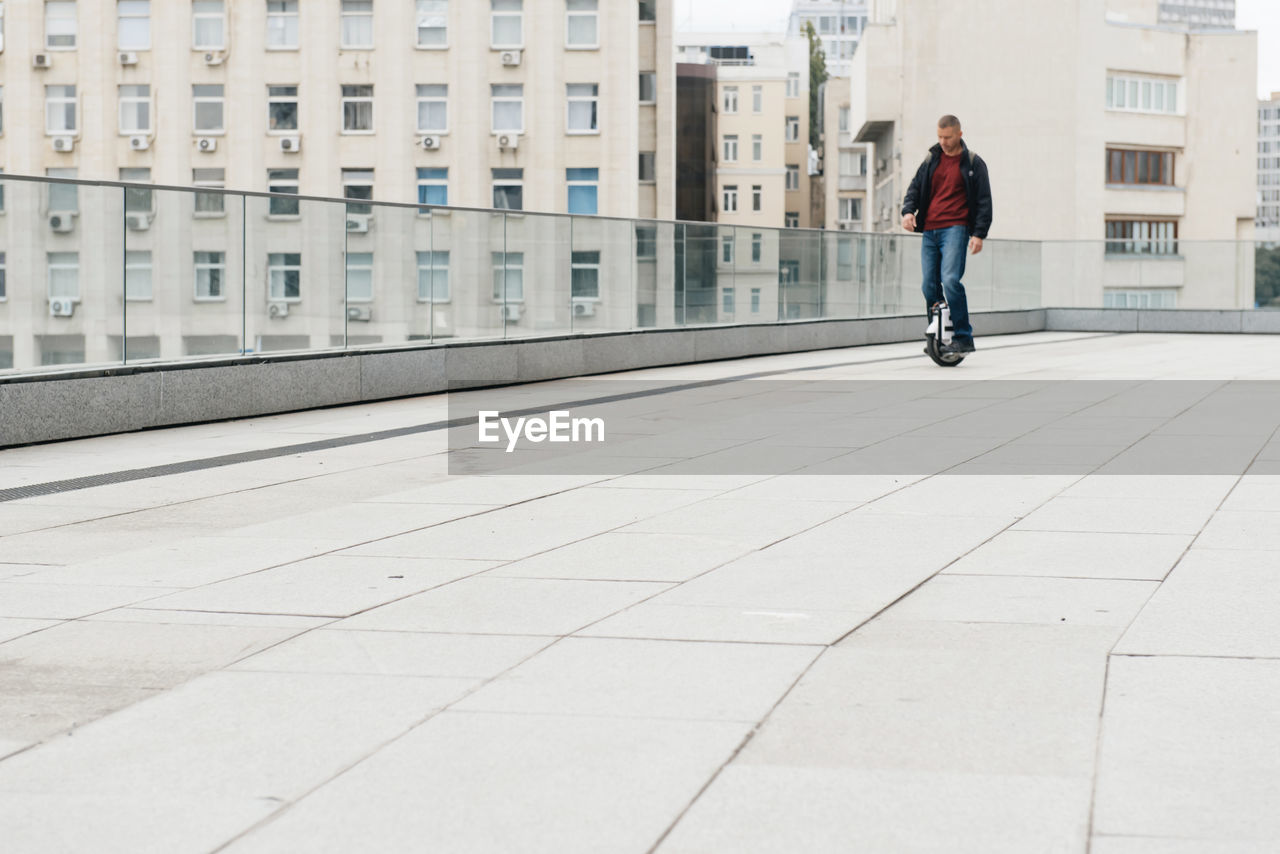 Man riding fast on electric unicycle on city street. mobile portable individual transportation