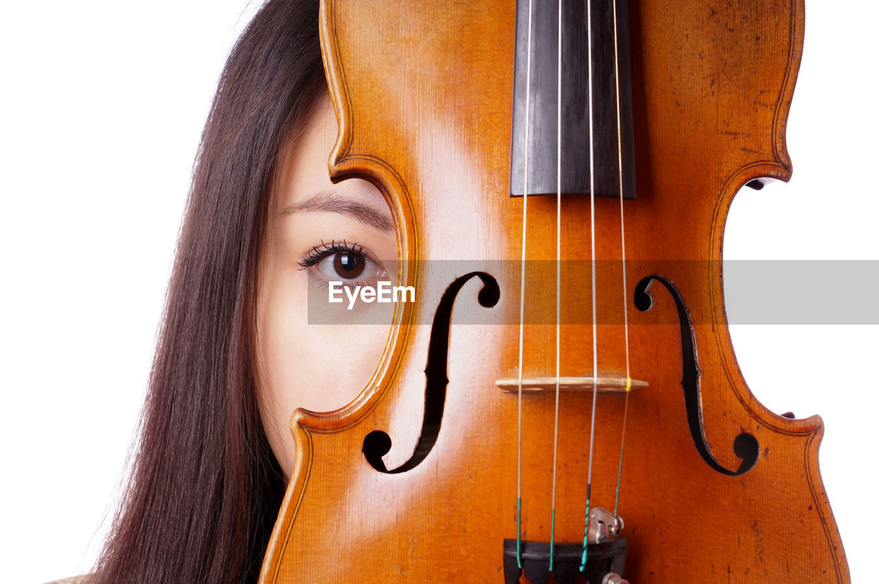 Portrait of young woman with violin against white background