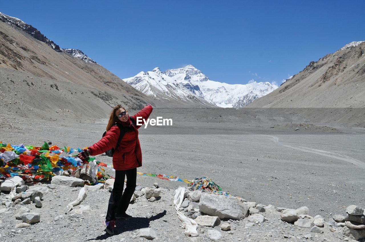 Woman with arms outstretched standing against mt everest