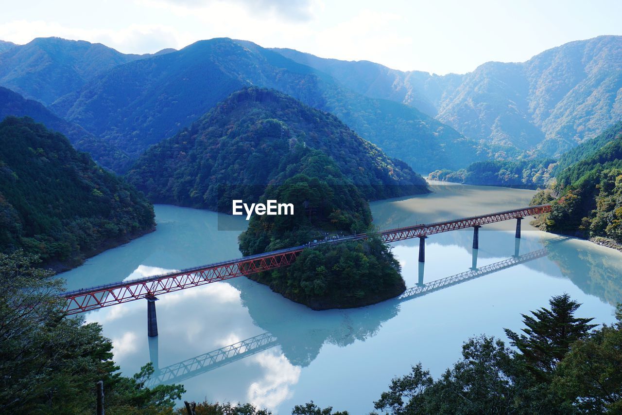 Lake bridge over mountains against sky