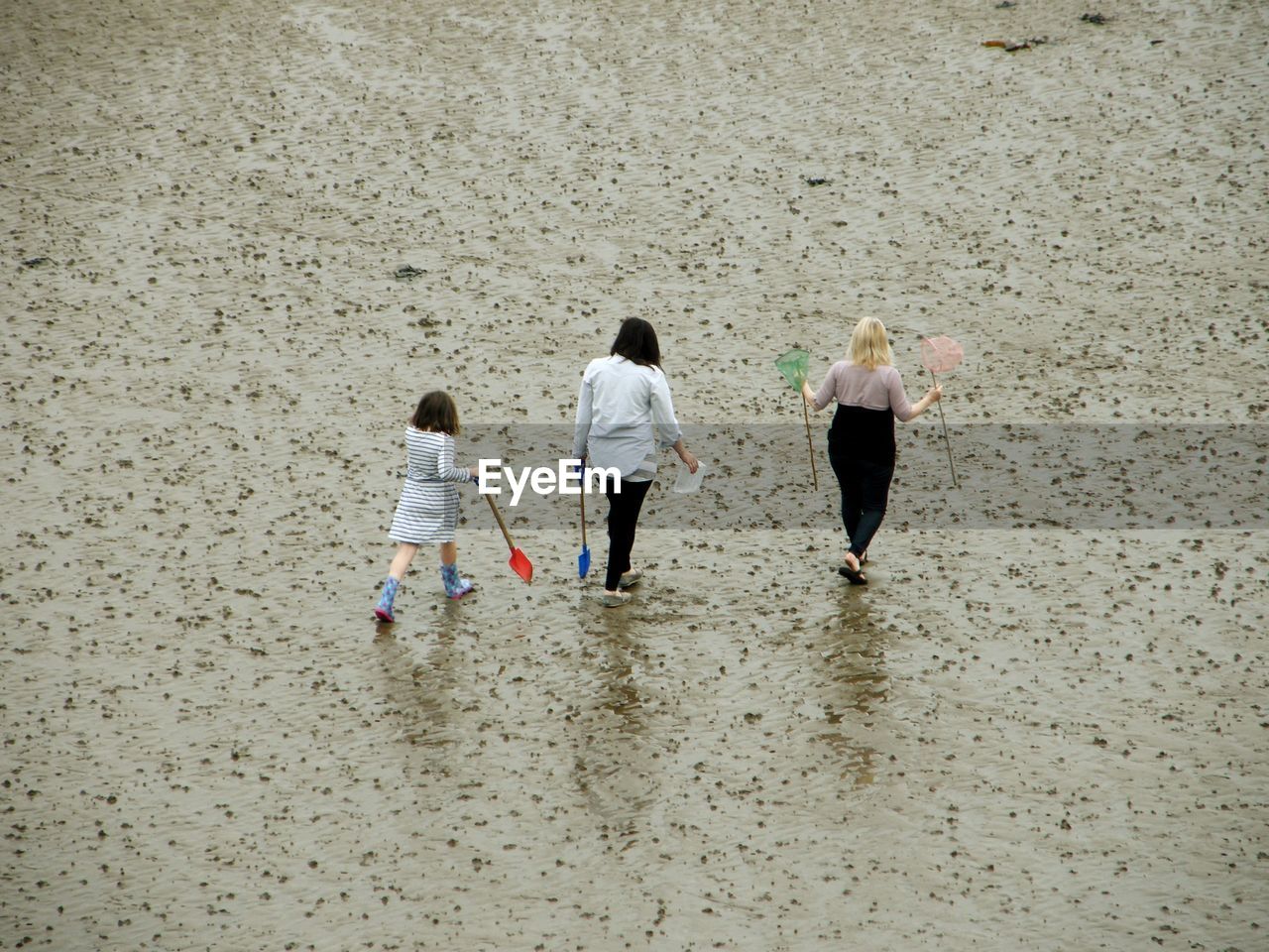 High angle view of women and girl walking at beach