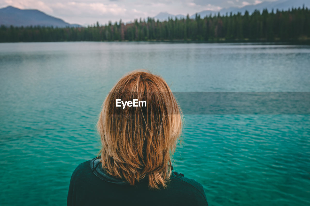 Rear view of woman against lake