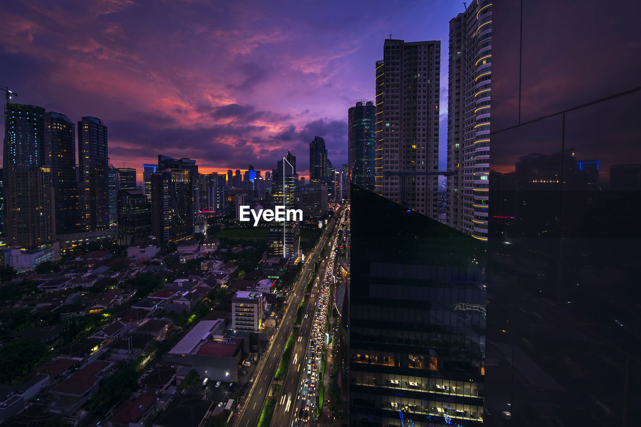 Aerial view of illuminated buildings against sky at night