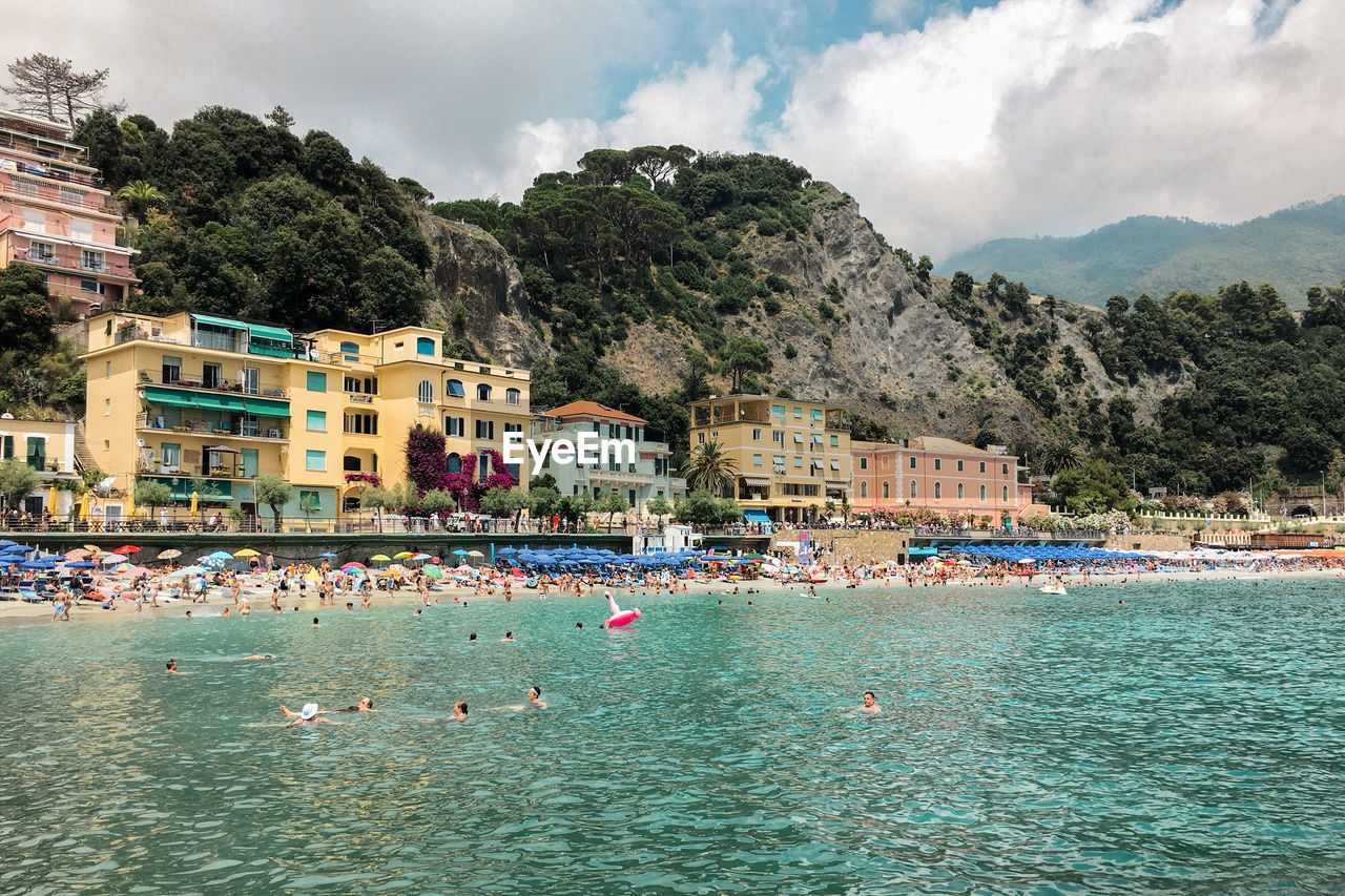 Scenic view of sea by buildings against sky