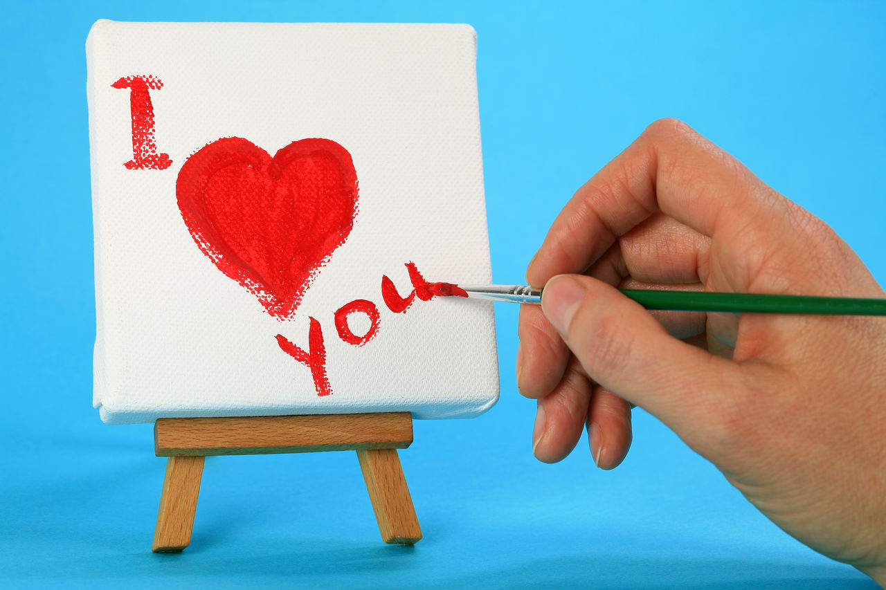 CLOSE-UP OF HAND HOLDING HEART SHAPE MADE FROM PAPER