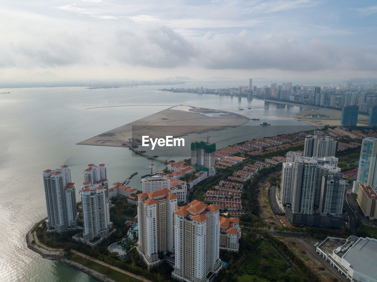 HIGH ANGLE VIEW OF SEA BY BUILDINGS AGAINST SKY