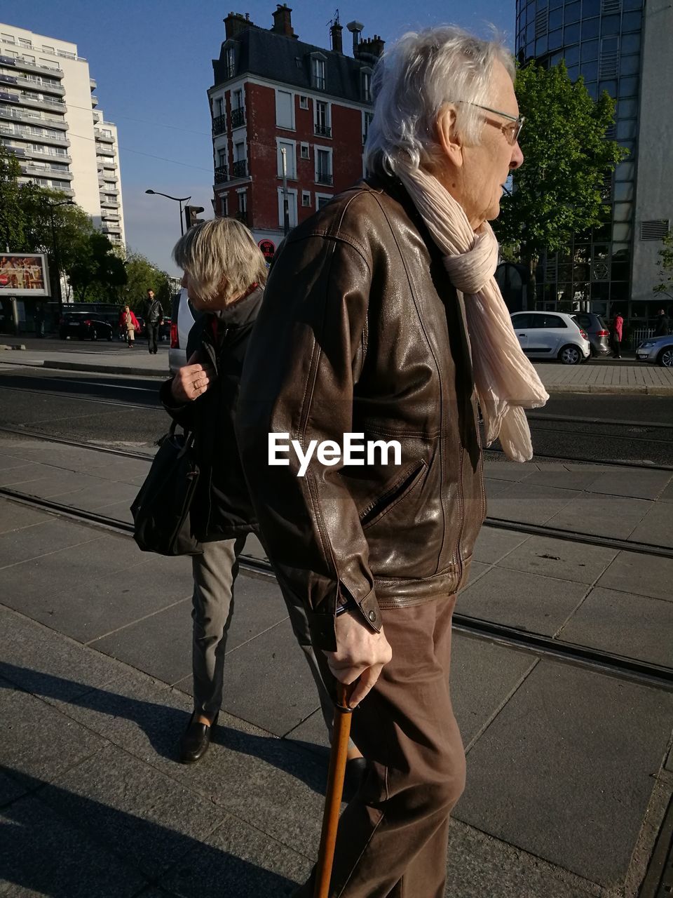 WOMAN STANDING ON STREET AGAINST CITY